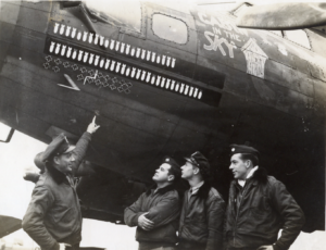 crew looking at nose art of B-17 named Cabin in the Sky